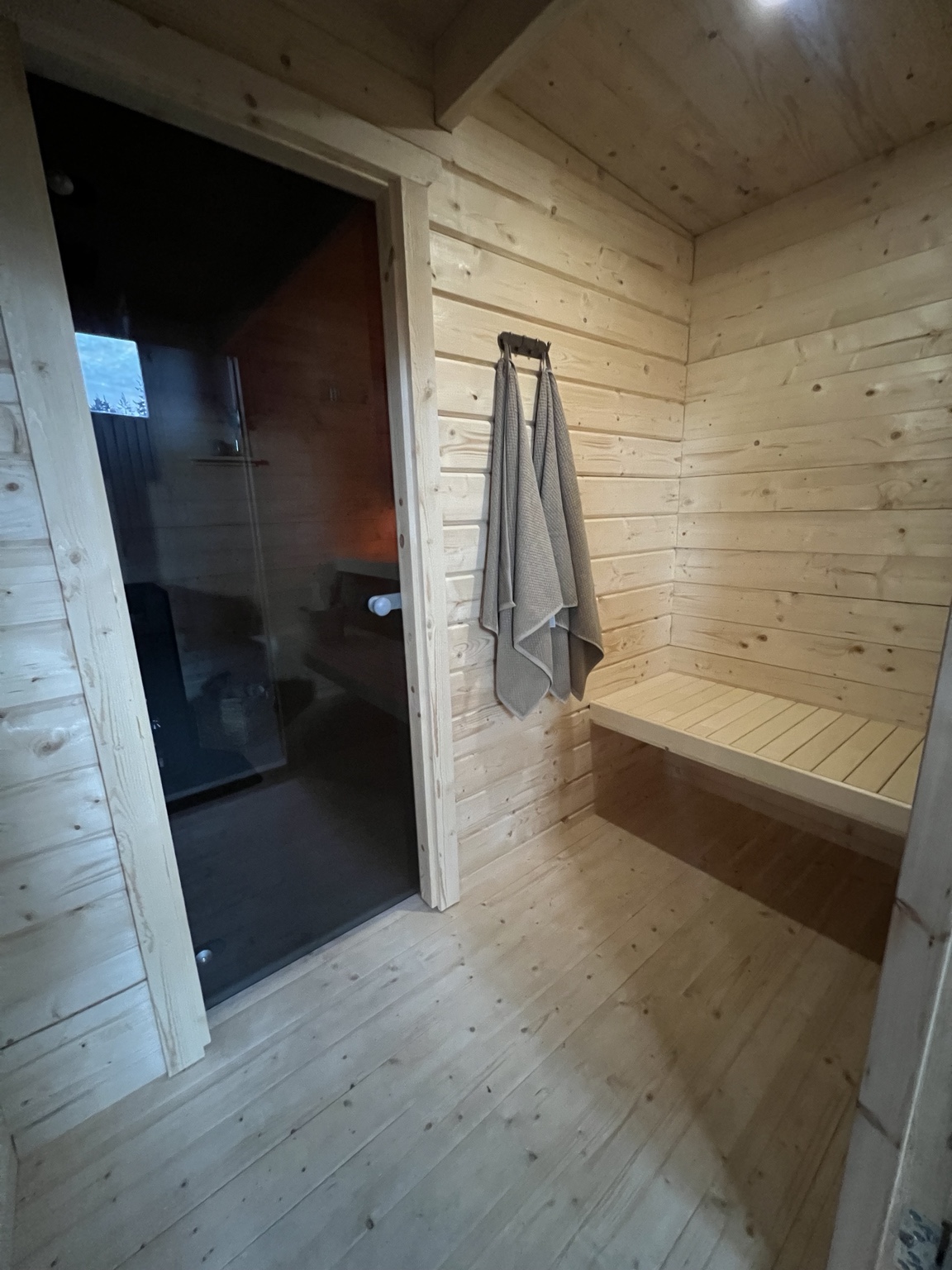 Lunas omklädningsdel med träväggar och sittbänk.