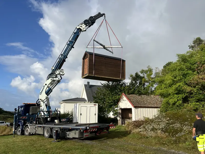 Färdig bastustuga lyfts med kran vid leverans